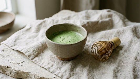 Handmade stoneware matcha bowl (chawan) with freshly whisked matcha and a bamboo chasen