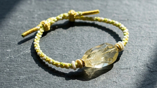 Raw citrine feng shui bracelet on sunlit slate — real KAGAKI product, editorial scene