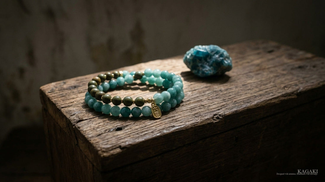 KAGAKI Forest handmade blue apatite and sandalwood bracelet at rest on aged walnut beside a small raw blue apatite stone in soft afternoon daylight, shown as an editorial hero image for a guide on choosing a handmade spiritual bracelet.