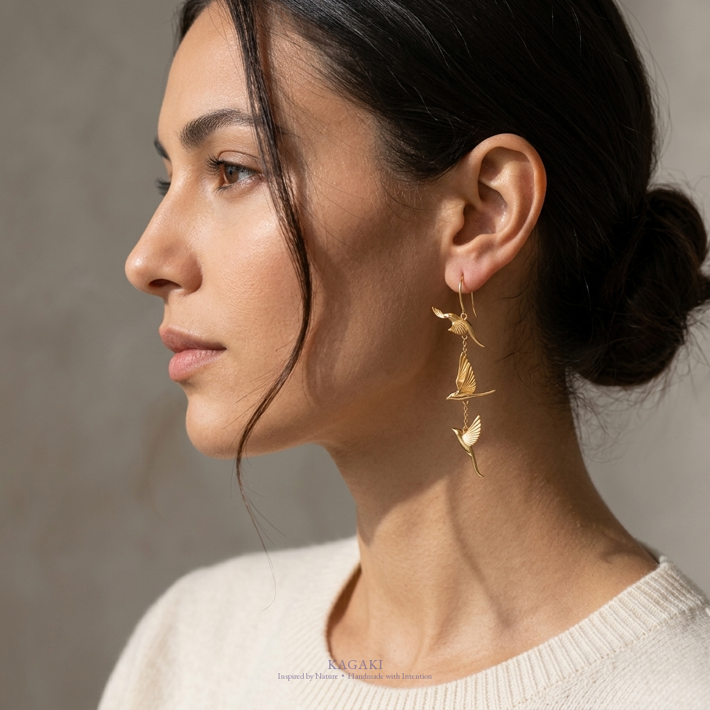 KAGAKI gold flying-swallow handmade dangle earrings — side profile editorial view.