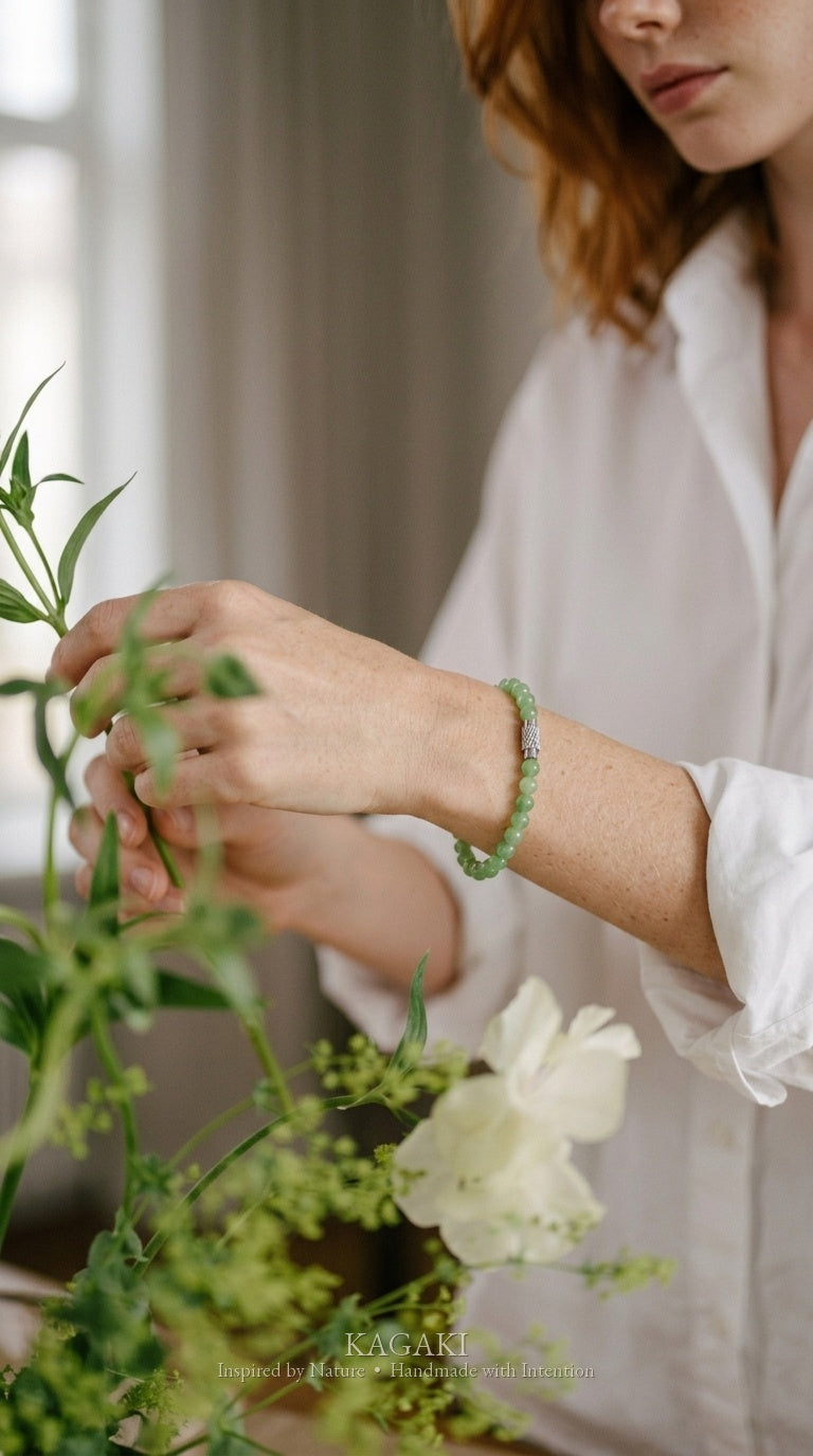 Green jade beaded bracelet on the wrist — vertical