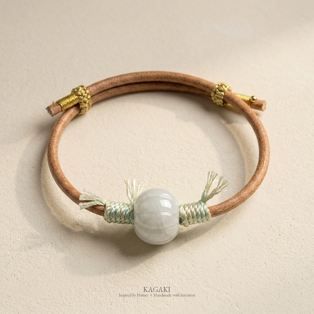 KAGAKI Canyon smooth pale green Jadeite barrel bead leather cord bracelet, green tassel wraps, gold-thread slider, studio vie