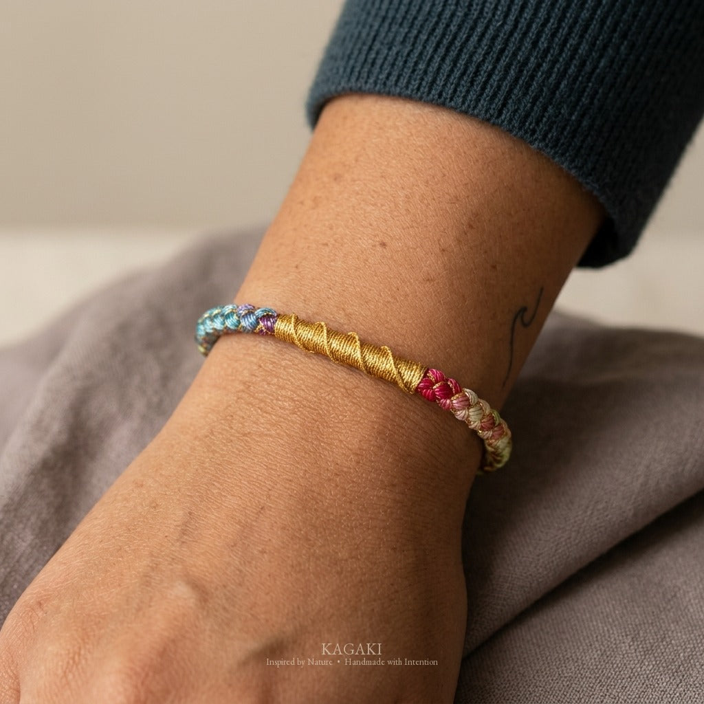 KAGAKI handmade cord bracelet rainbow gradient braided cord bracelet — full rainbow + gold thread, natural lifestyle wrist detail.