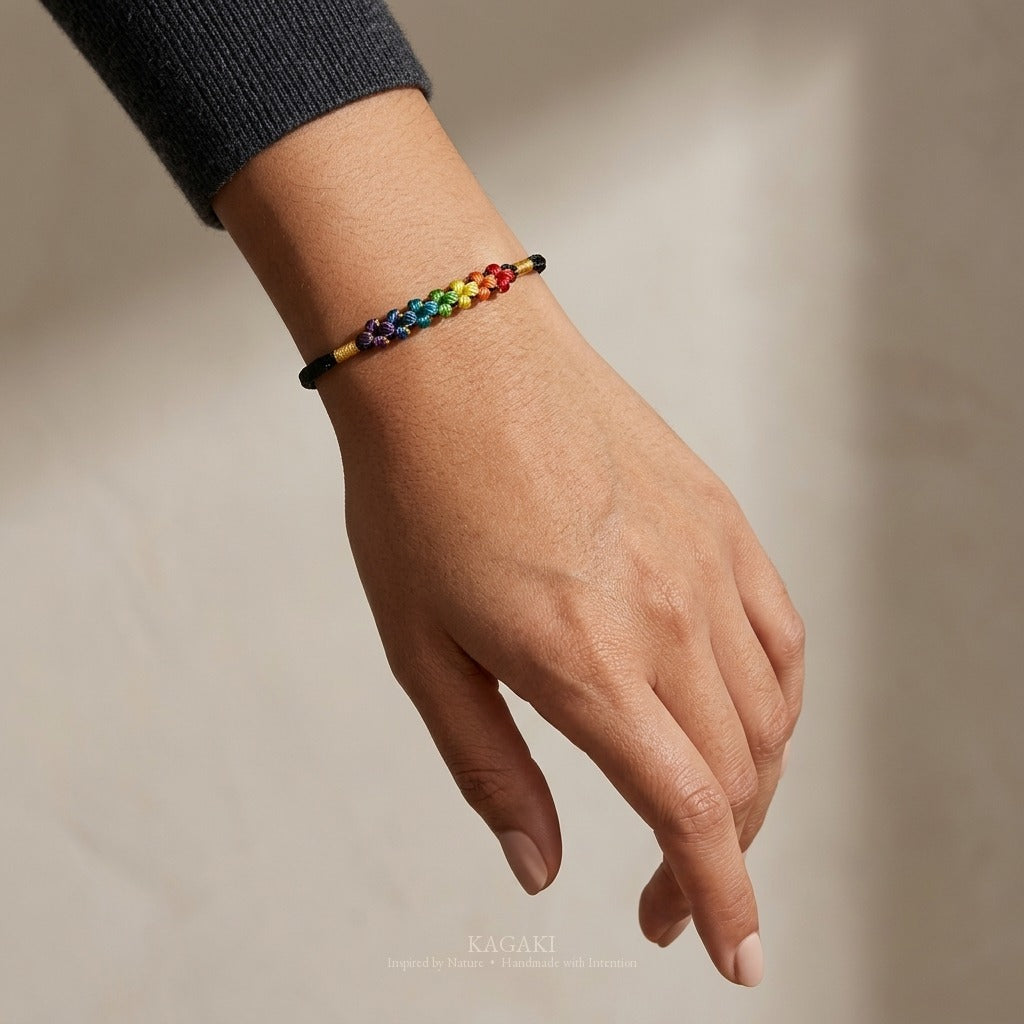 KAGAKI handmade cord bracelet rainbow sakura knot cord bracelet — black with rainbow knotted florals, luxury jewelry editorial wearing shot.