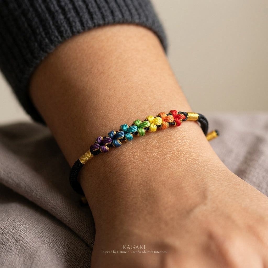 KAGAKI handmade cord bracelet rainbow sakura knot cord bracelet — black with rainbow knotted florals, natural lifestyle wrist detail.