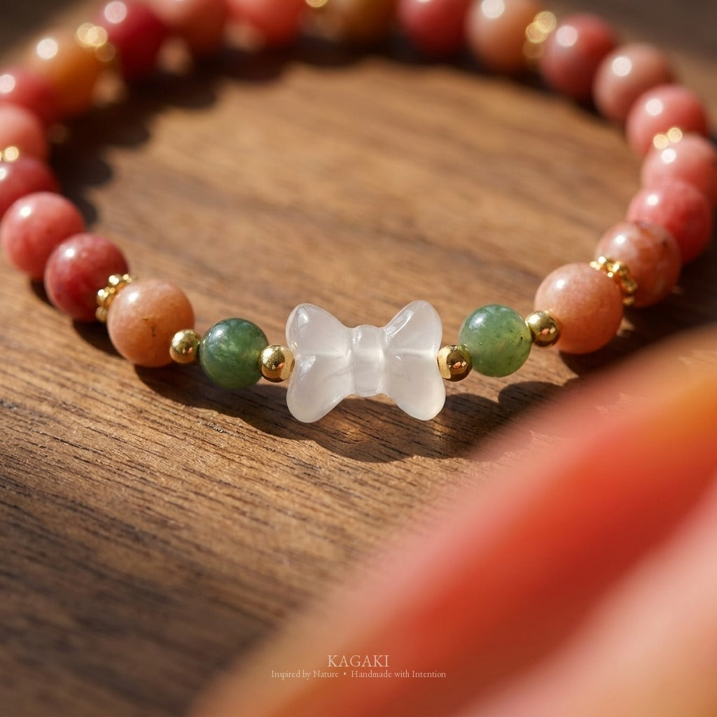 KAGAKI handmade crystal bracelet pink stone beaded bow stretch bracelet — pink + white + gold, editorial styled scene.