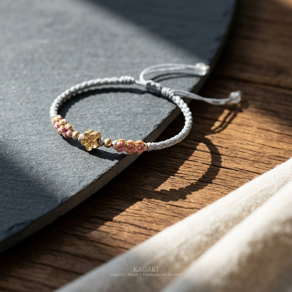 KAGAKI handmade cord bracelet sakura pastel cord bracelet (mist & petal) — mist blue or dawn pink with gold accent, editorial styled scene.
