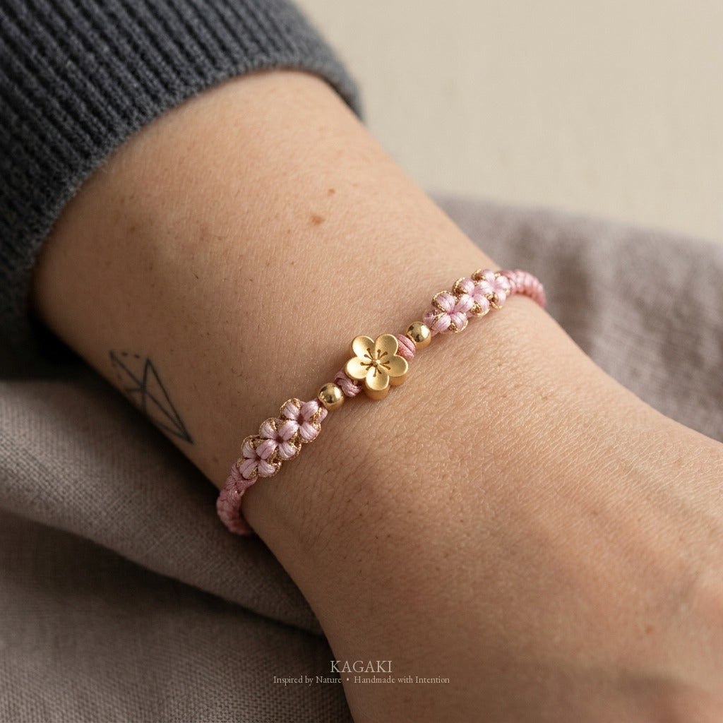 KAGAKI handmade cord bracelet sakura pastel cord bracelet (dawn & petal) — mist blue or dawn pink with gold accent, natural lifestyle wrist detail.
