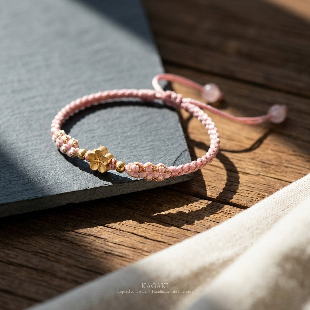 KAGAKI handmade cord bracelet sakura pastel cord bracelet (dawn & petal) — mist blue or dawn pink with gold accent, editorial styled scene.