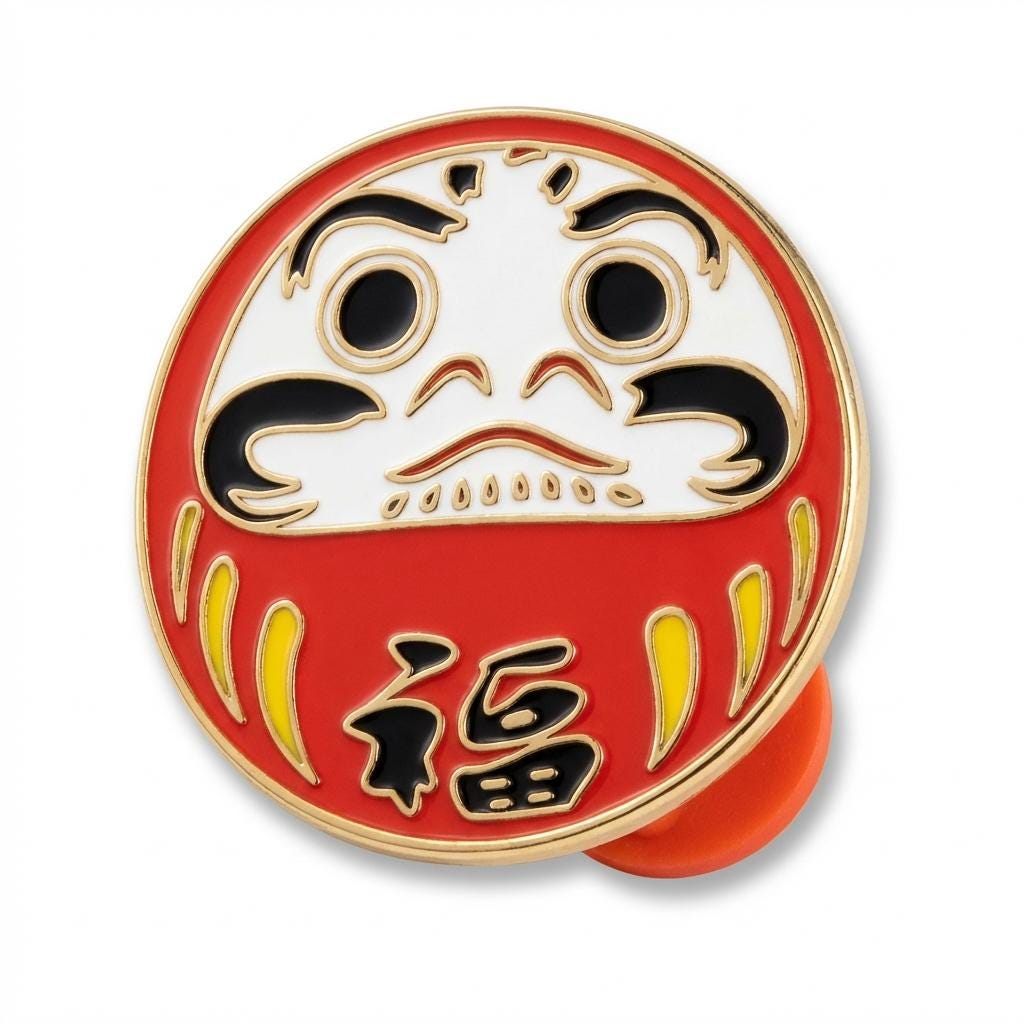 KAGAKI daruma lucky enamel pin in classic Daruma red and gold, flat lay, for daily wear and gifting