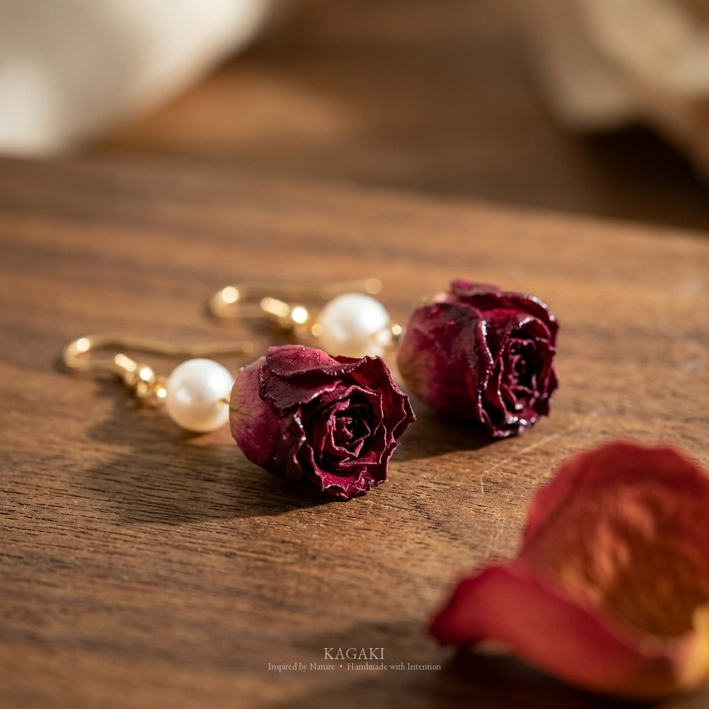 Macro detail of the preserved real rose bud's natural petal layers and dehydration curl beside the white freshwater pearl on the KAGAKI earring