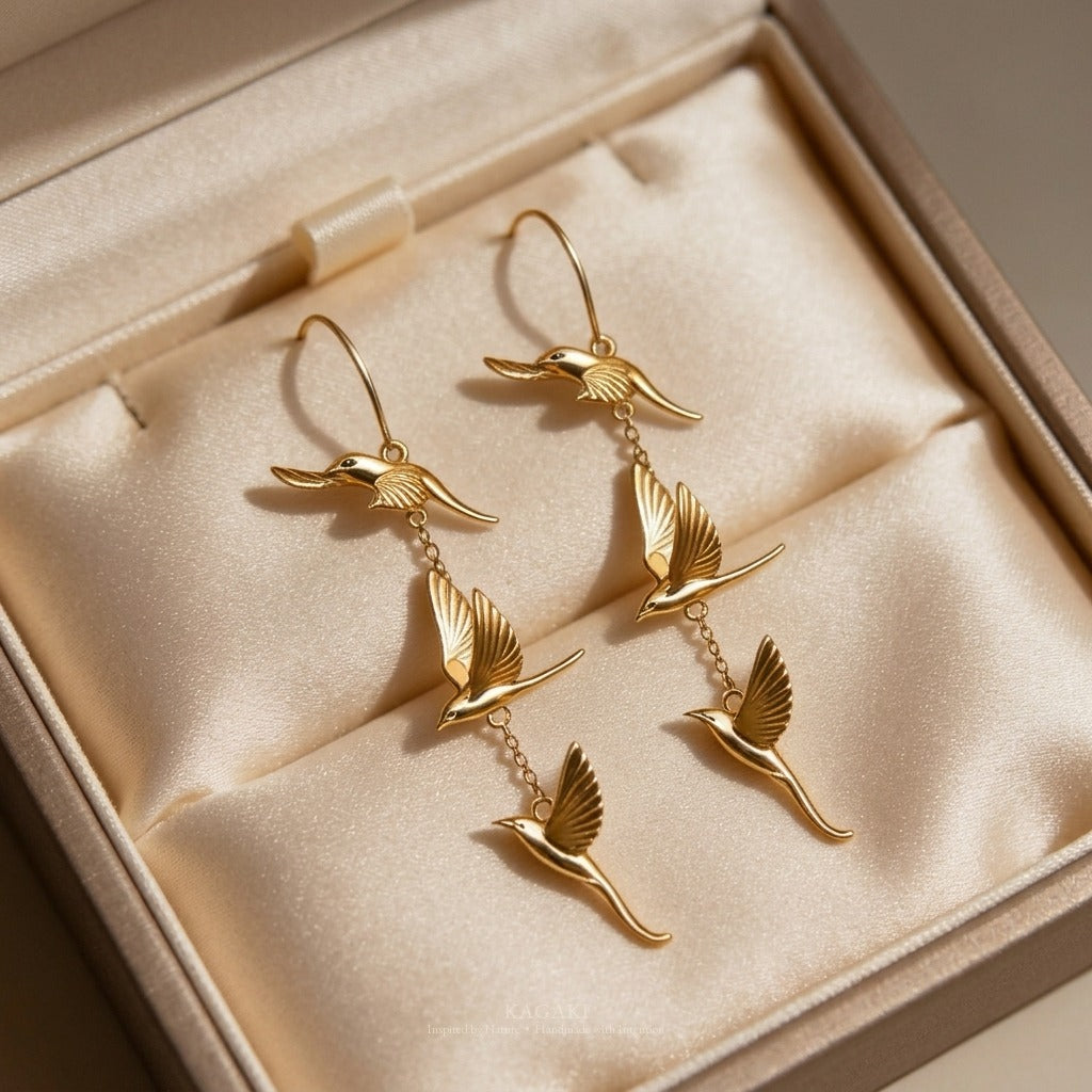 KAGAKI gold flying-swallow earrings displayed in a KAGAKI gift-ready packaging — a quiet luxury jewelry gift moment.