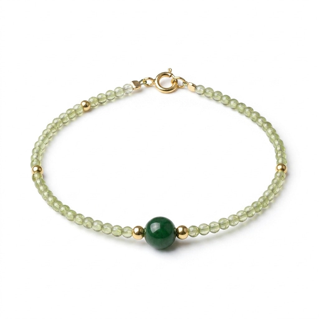 KAGAKI handmade green jade crystal bracelet with a dark green jade focal bead and small gold spacers, photographed on pure white background.