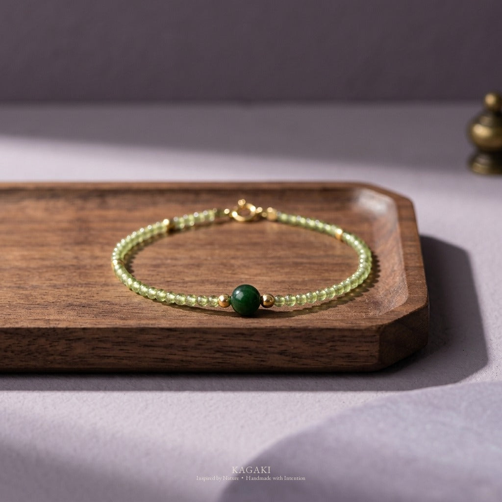 KAGAKI green jade crystal bracelet on a dark walnut altar tray with smoky lavender plaster surround — refined fine-jewelry editorial.