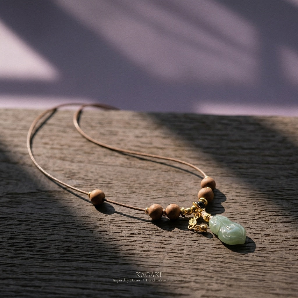 KAGAKI Plume green jade feather pendant sandalwood cord necklace, studio styled view, handmade feather necklace