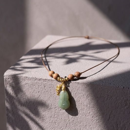 KAGAKI Plume green jade feather pendant sandalwood cord necklace, studio styled view, handmade feather necklace