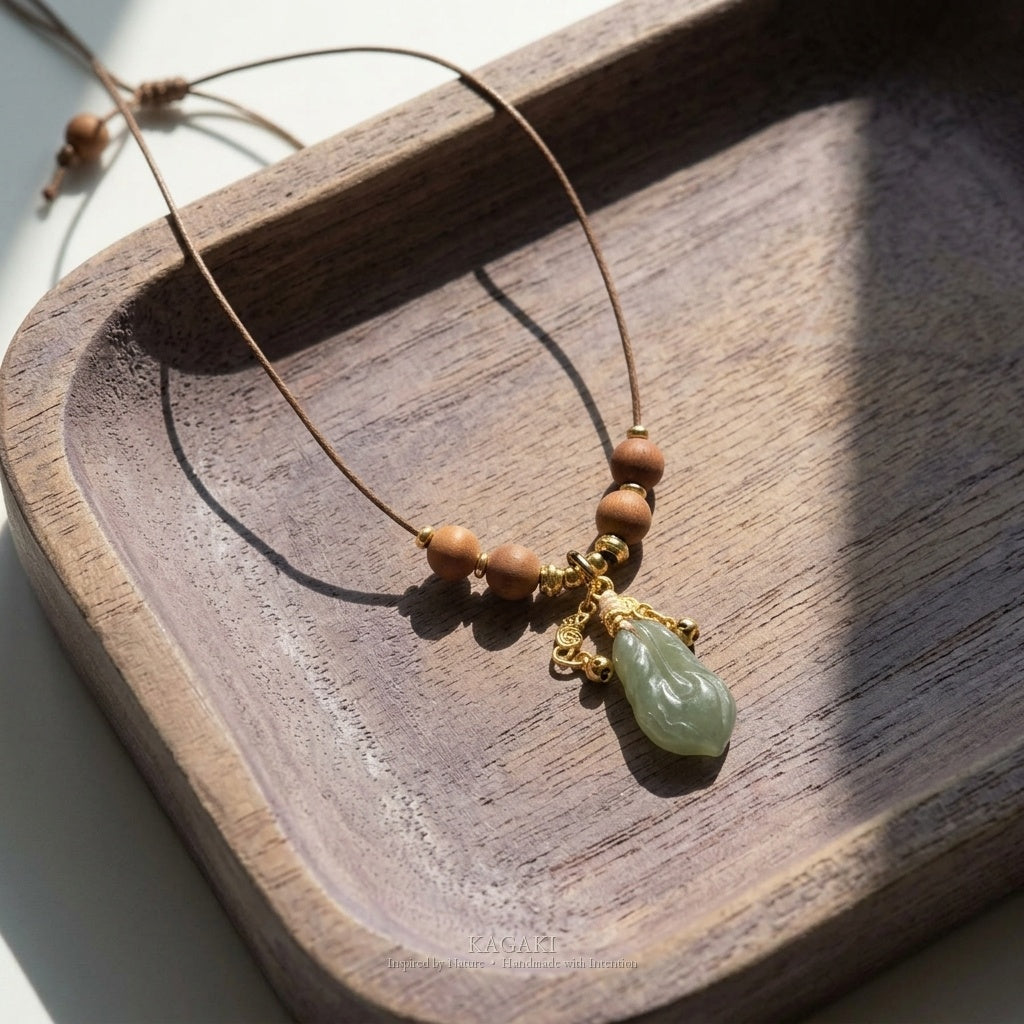 KAGAKI Plume green jade feather pendant sandalwood cord necklace, studio styled view, handmade feather necklace