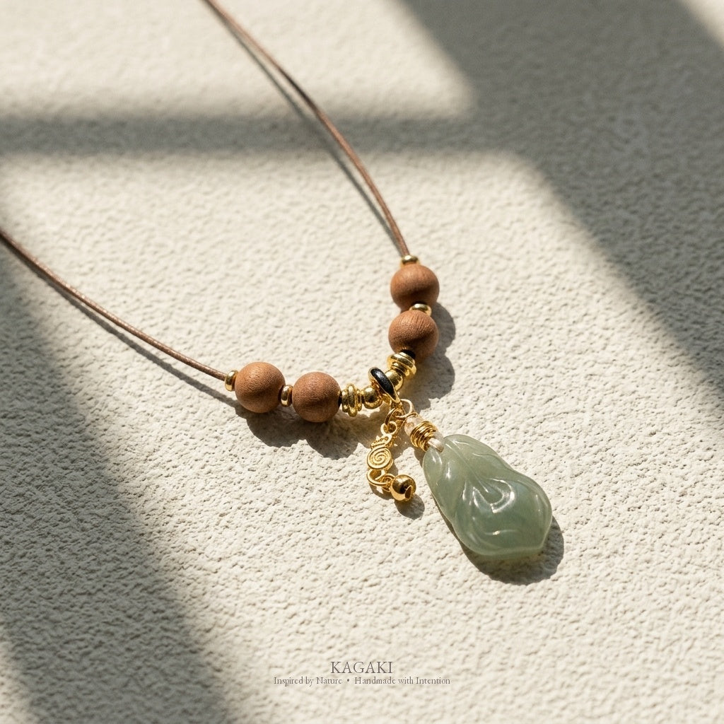 KAGAKI Plume green jade feather pendant sandalwood cord necklace, studio styled view, handmade feather necklace