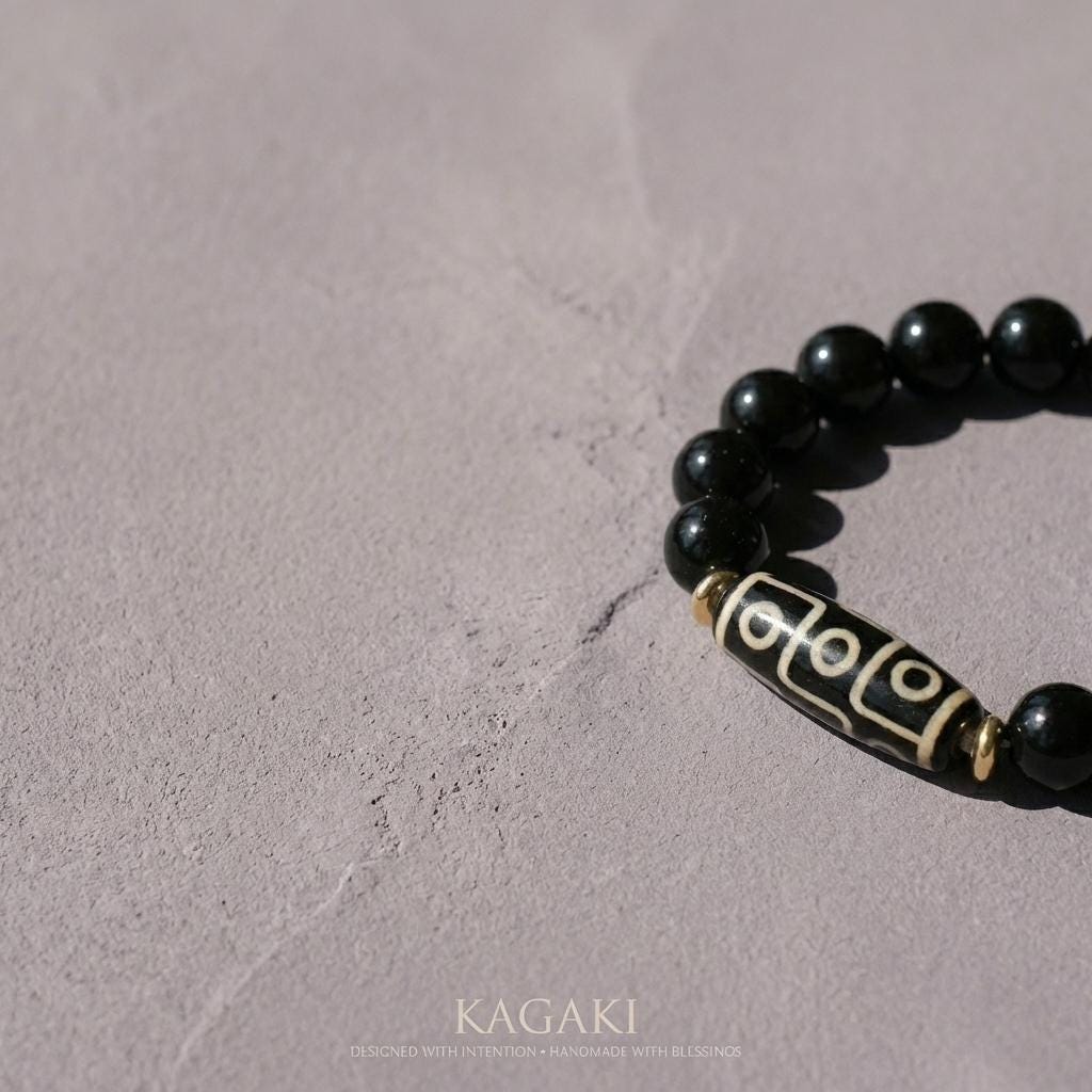 KAGAKI obsidian dzi bead bracelet in deep black obsidian, flat lay, for meditation and daily intention