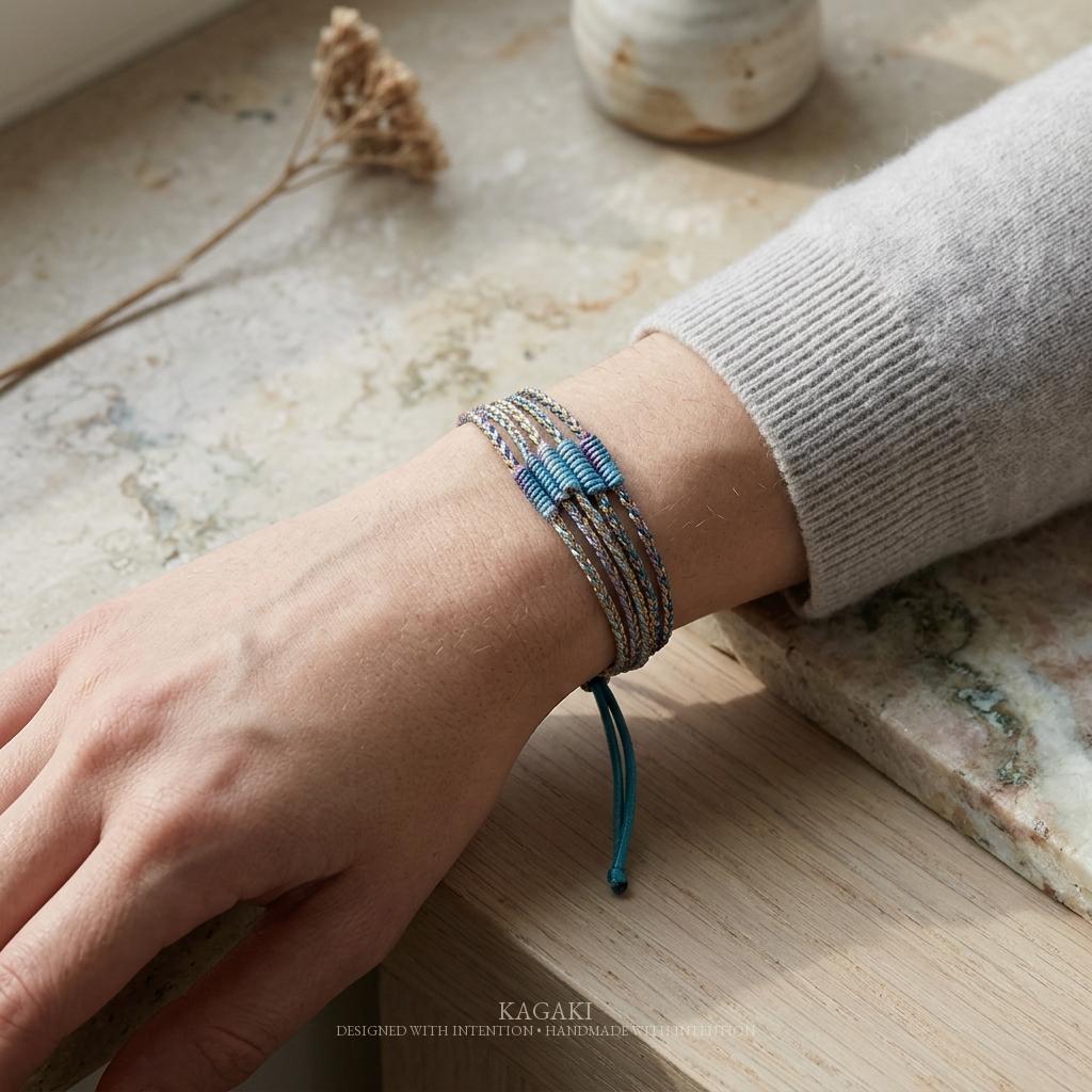 KAGAKI rainbow tibetan cord bracelet in rainbow multicolor, flat lay, for meditation and daily intention