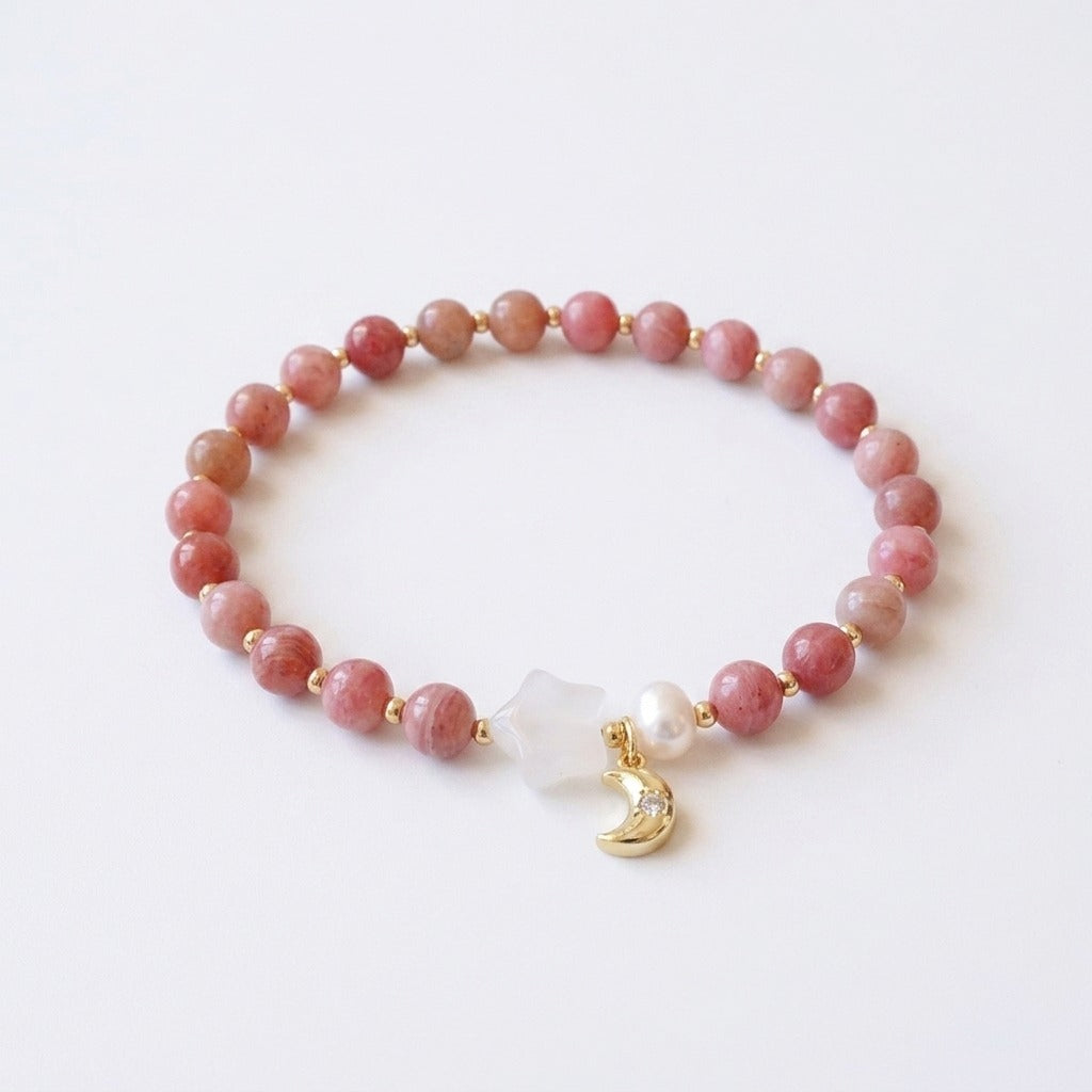 KAGAKI handmade rhodochrosite bracelet with a white chalcedony star, freshwater pearl, and gold-tone crescent moon charm, on pure white background.